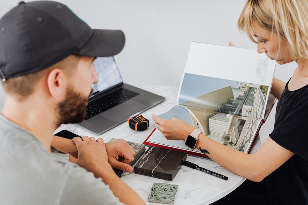 Two interior designers discussing architectural plans in an office setting.