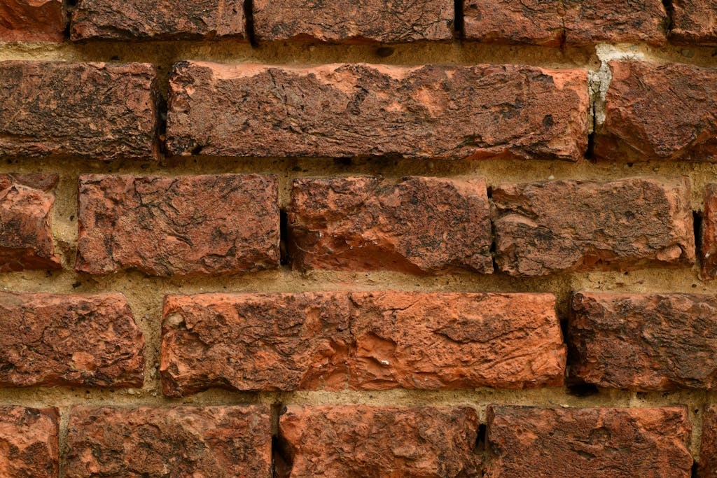 Close-up of a textured red brick wall highlighting rough surfaces.